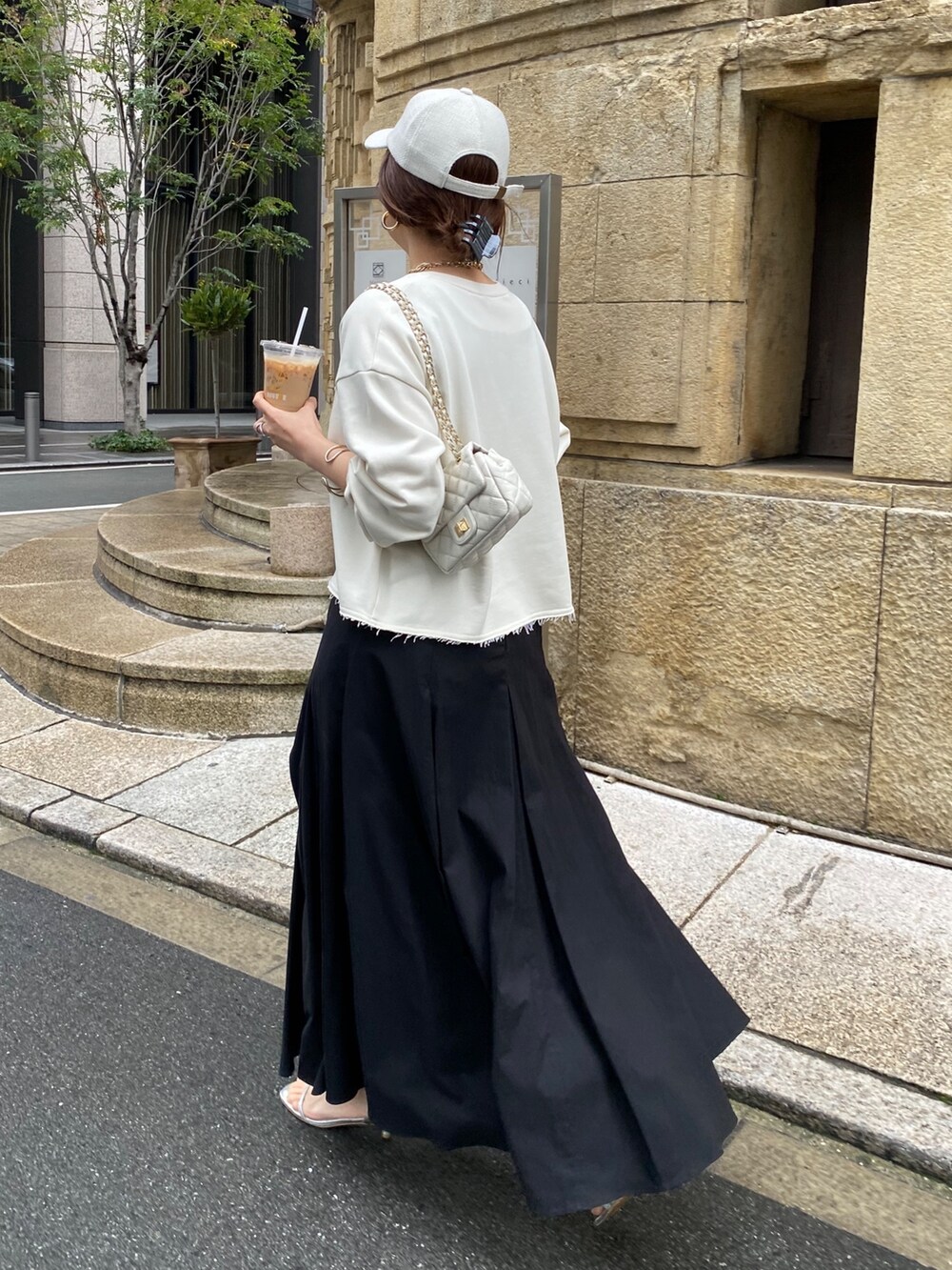 ベージュ系のスウェット、ブラック系のスカート、ホワイト系のショルダーバッグを着用したレディースの冬コーディネートの7枚目の写真