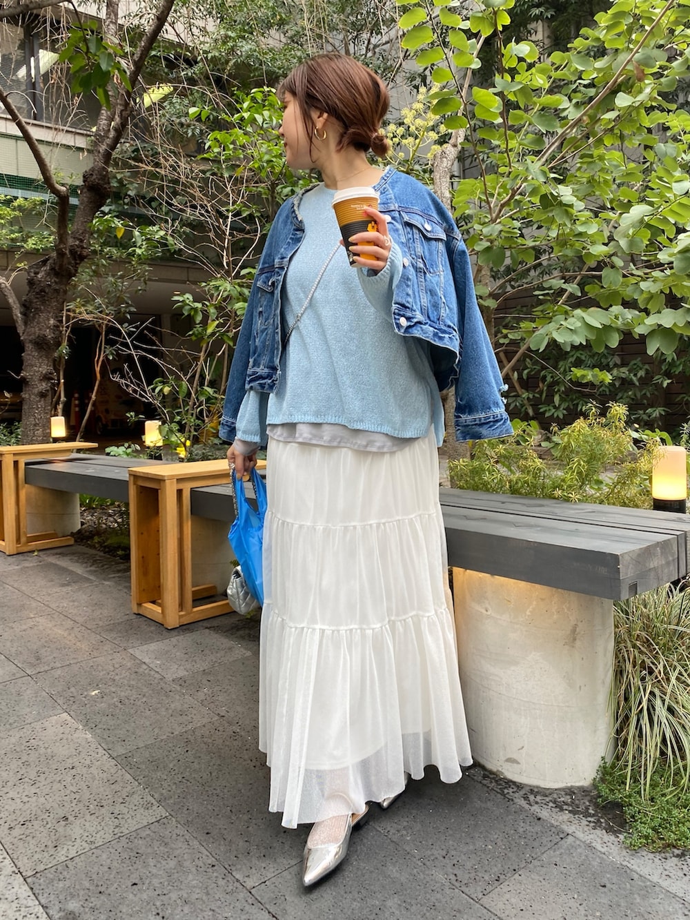 ブルー系のデニムジャケット、グレー系のニット/セーター、ホワイト系のTシャツ/カットソーを着用したレディースの春コーディネートの3枚目の写真