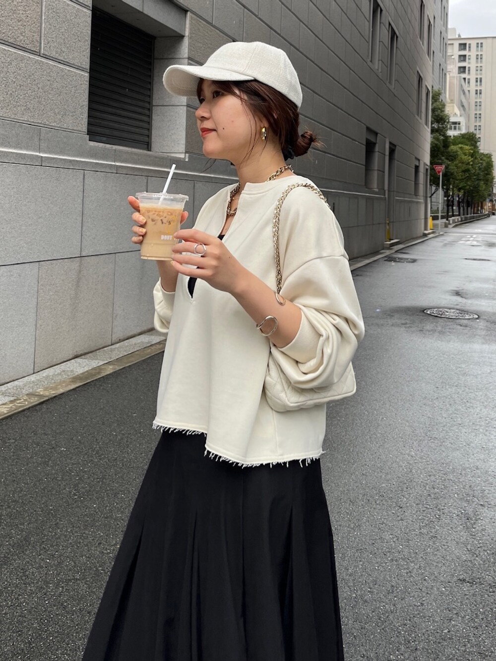 ベージュ系のスウェット、ブラック系のスカート、ホワイト系のショルダーバッグを着用したレディースの冬コーディネートの5枚目の写真