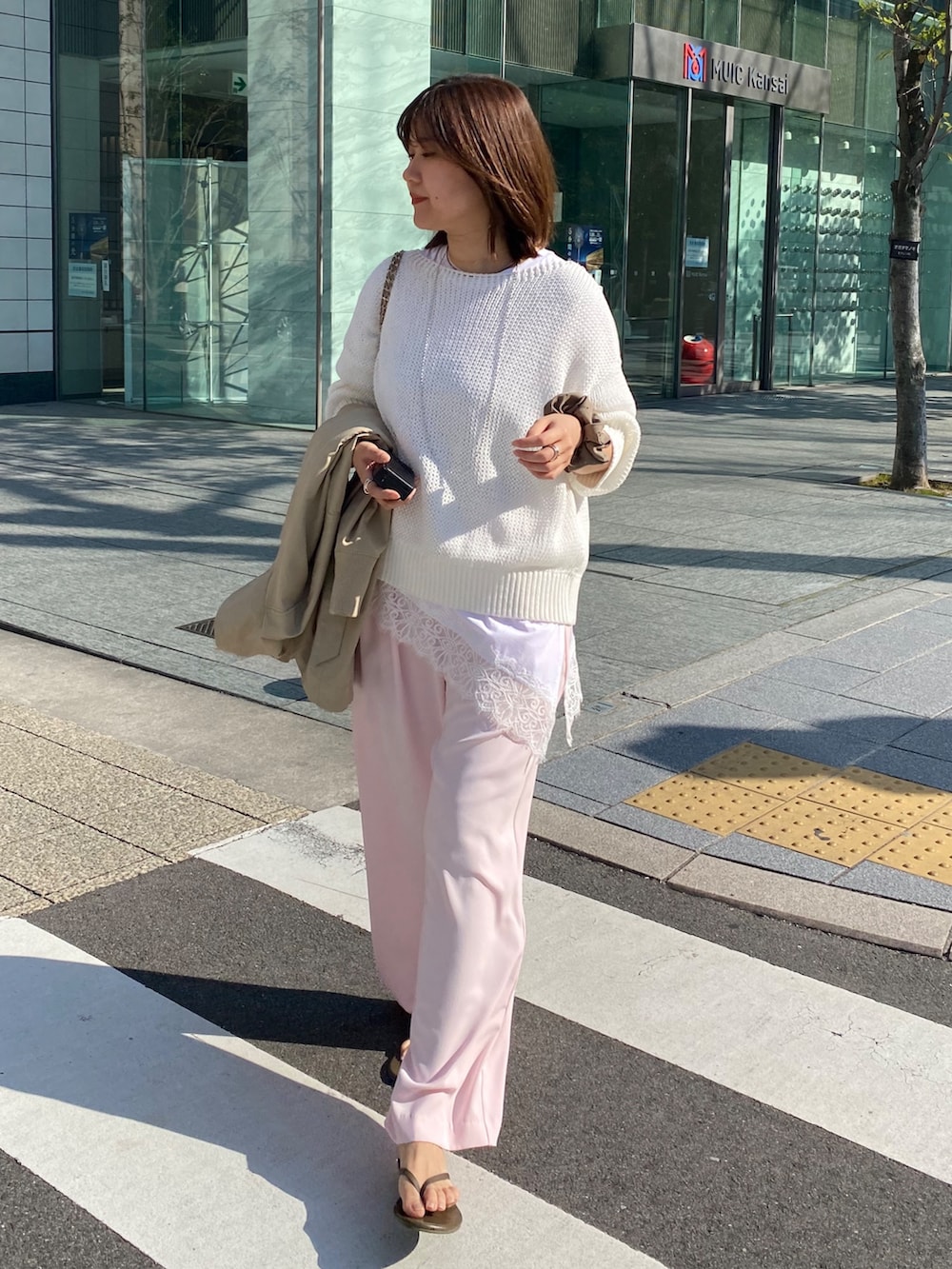 ホワイト系のTシャツ/カットソー、ピンク系のニット/セーター、ピンク系のスラックスを着用したレディースの春コーディネートの5枚目の写真