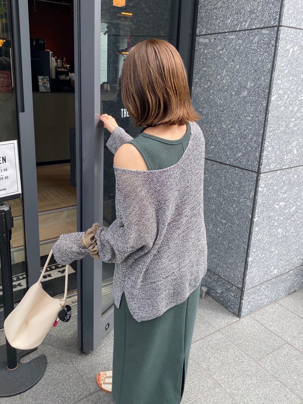 ブラック系のニット/セーター、グリーン系のワンピースを着用したレディースの夏コーディネートの8枚目の写真
