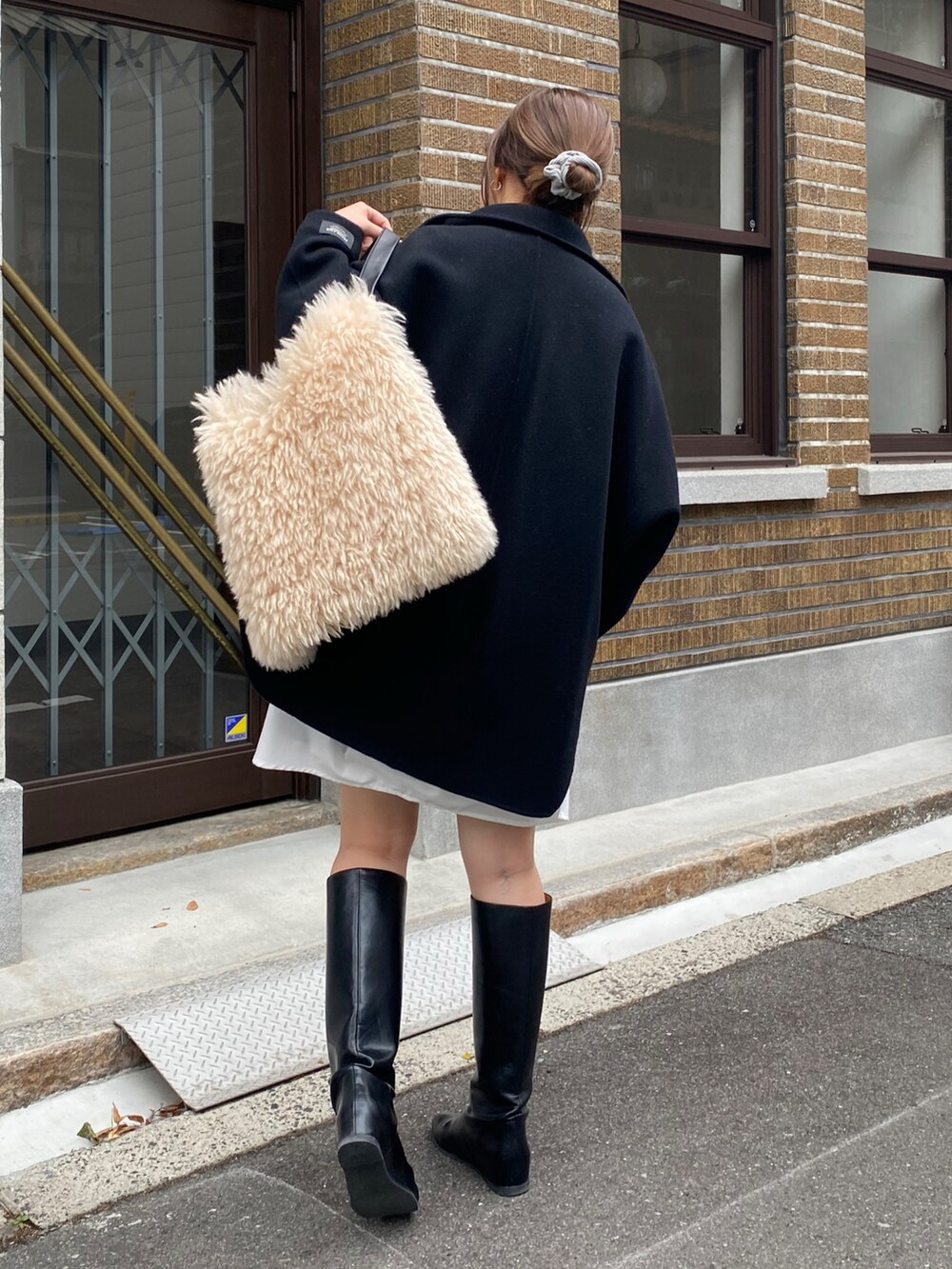 ブラック系のその他アウター、ブルー系のTシャツ/カットソー、ホワイト系のシャツ/ブラウスを着用したレディースの冬コーディネートの7枚目の写真