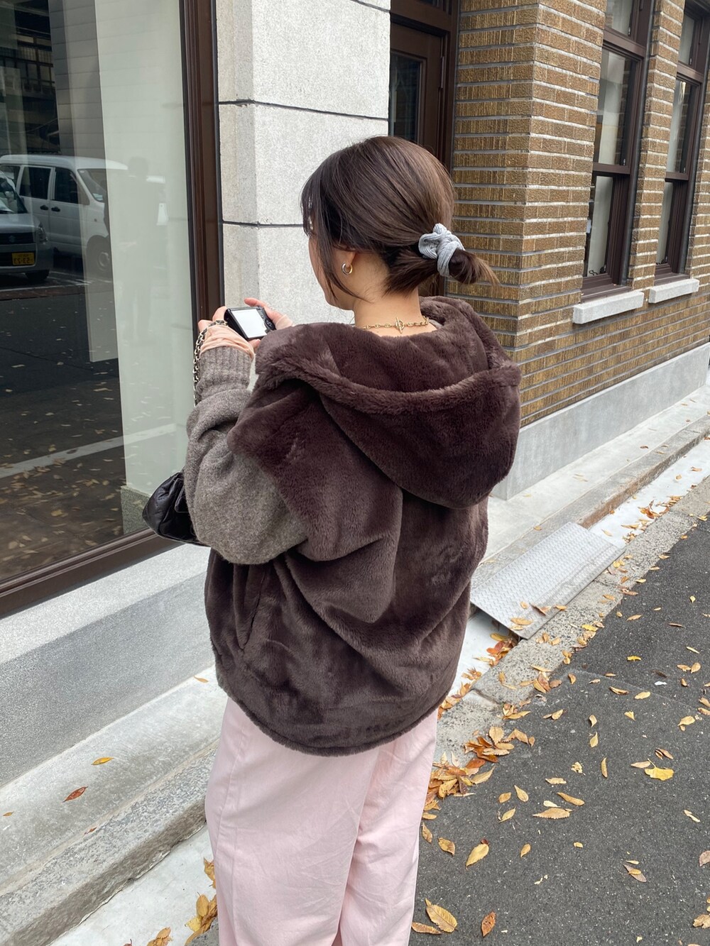 ブラウン系のベスト、ピンク系のTシャツ/カットソー、ベージュ系のニット/セーターを着用したレディースの冬コーディネートの2枚目の写真