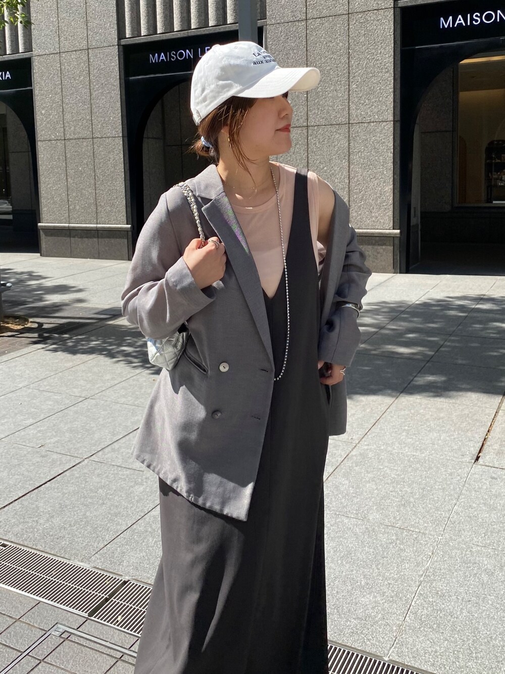 グレー系のワンピース、グレー系のテーラードジャケット、シルバー系のネックレスを着用したレディースの秋コーディネートの2枚目の写真