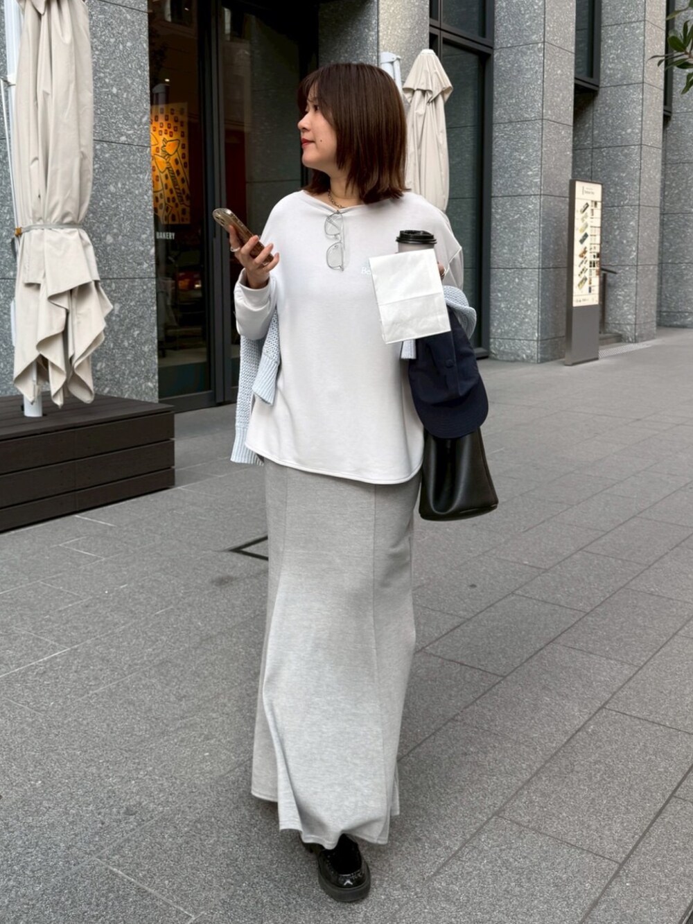 グレー系のTシャツ/カットソー、ブルー系のニット/セーター、グレー系のスカートを着用したレディースの冬コーディネートの2枚目の写真