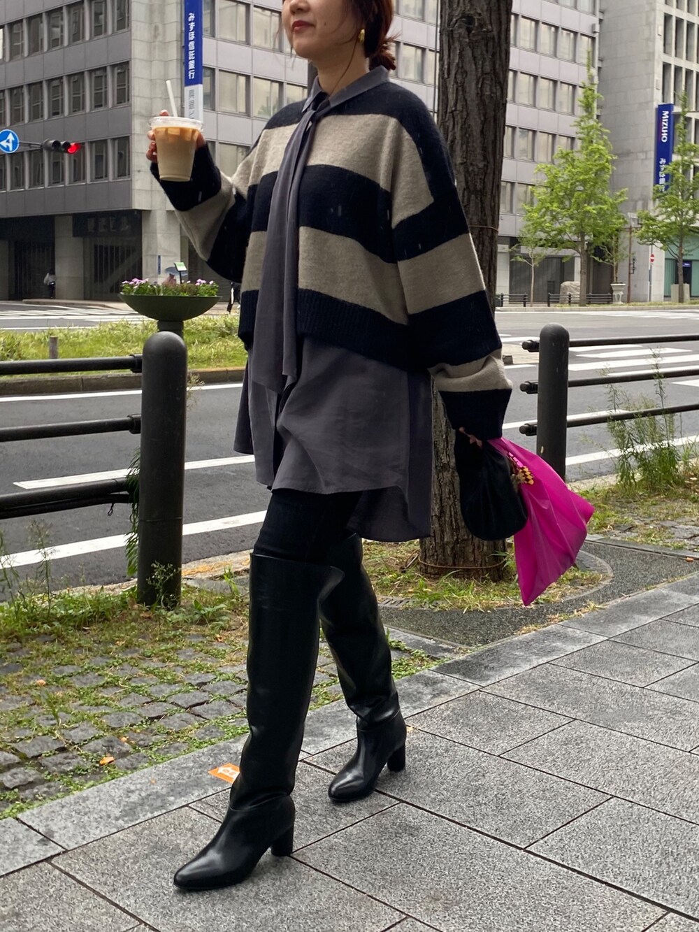 グレー系のシャツ/ブラウス、ブラック系のデニムパンツ、ブラック系のブーツを着用したレディースの冬コーディネートの9枚目の写真