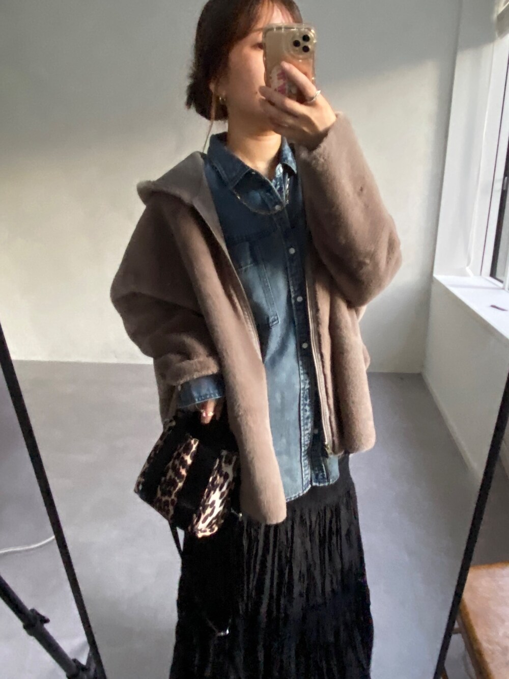 グレー系のムートンコート、ブルー系のシャツ/ブラウス、ブラック系のスカートを着用したレディースの冬コーディネートの3枚目の写真