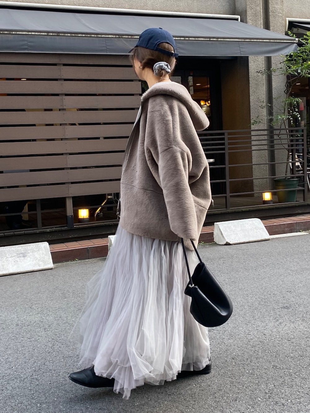 グレー系のムートンコート、グレー系のTシャツ/カットソー、グレー系のスカートを着用したレディースの冬コーディネートの7枚目の写真