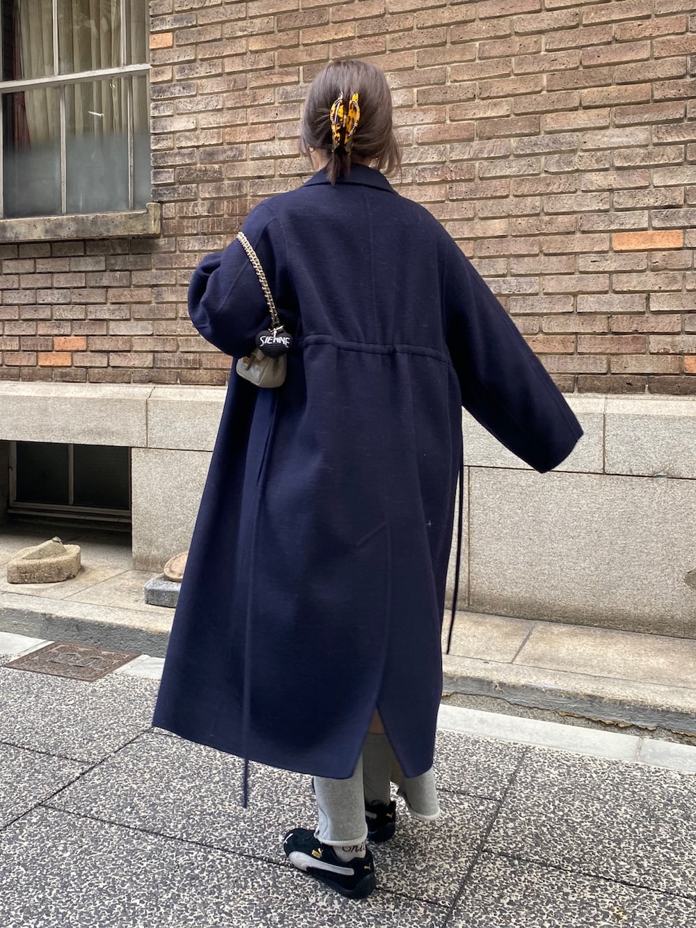 ブルー系のその他アウター、グレー系のニット/セーター、グレー系のスカートを着用したレディースの冬コーディネートの2枚目の写真