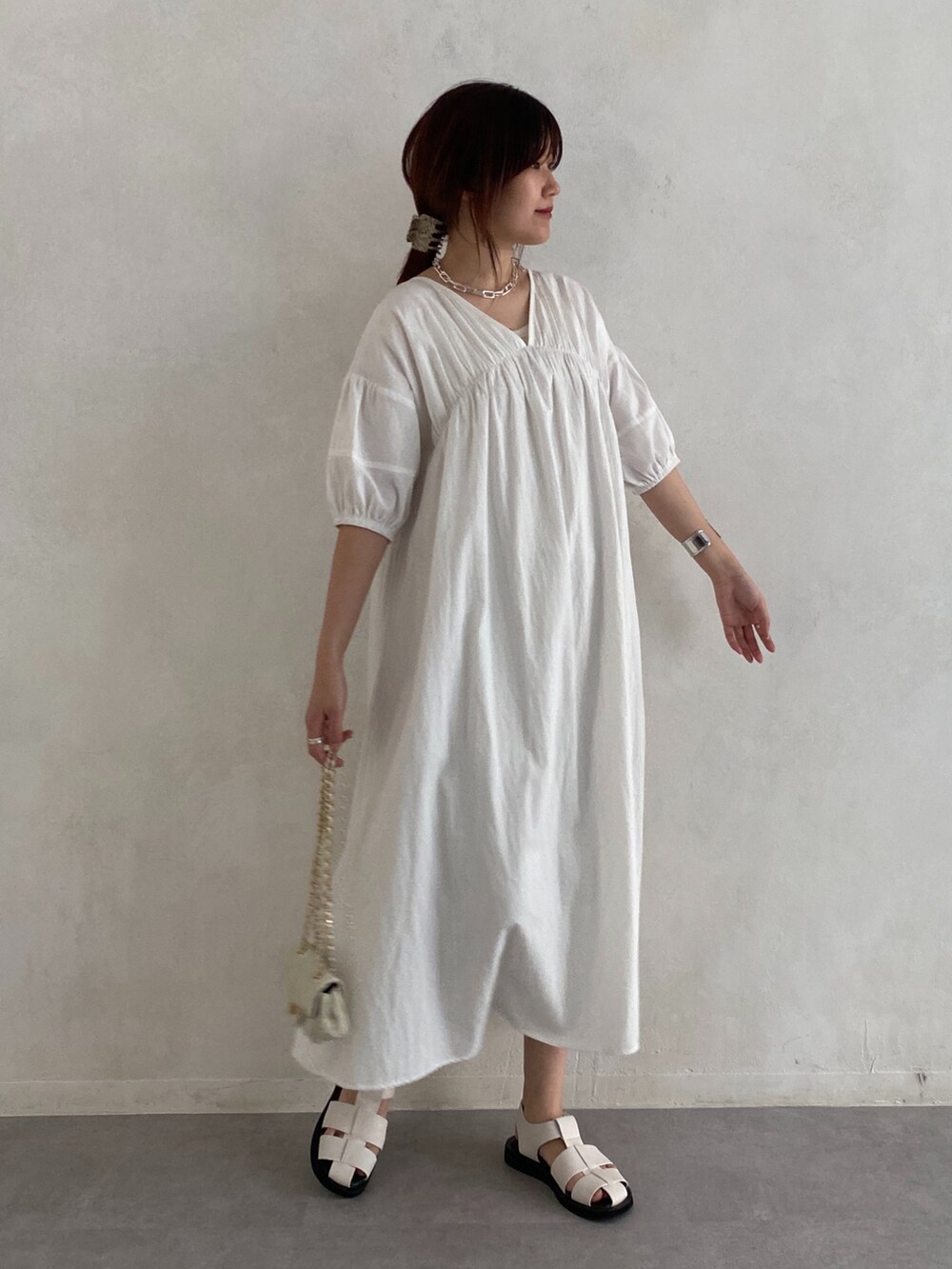 ホワイト系のワンピース、ブラック系のその他シューズ、ホワイト系のショルダーバッグを着用したレディースの夏コーディネートの3枚目の写真