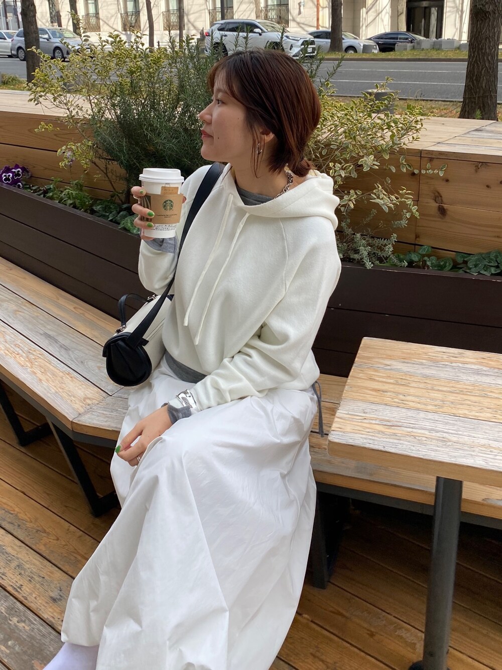 ホワイト系のスカート、ブラウン系のショルダーバッグ、グレー系のTシャツ/カットソーを着用したレディースの春コーディネートの2枚目の写真