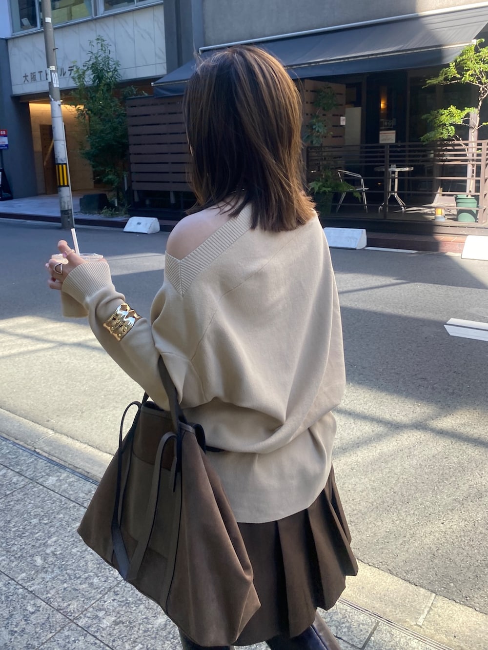 ベージュ系のニット/セーター、ブラウン系のスカート、ブラウン系のショルダーバッグを着用したレディースの冬コーディネートの4枚目の写真