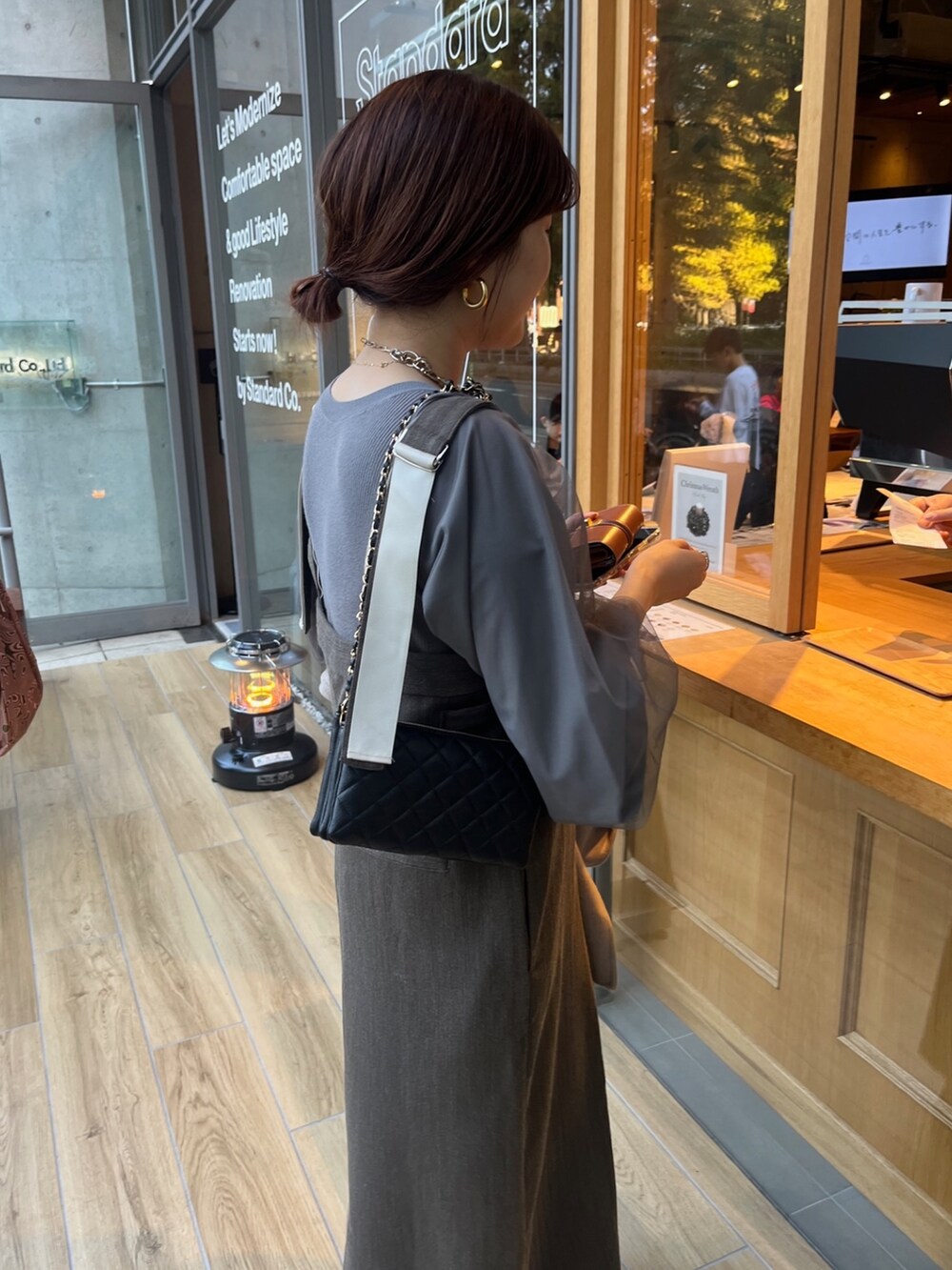 グレー系のニット/セーター、ブラウン系のジャンパースカート、イエロー系のその他アウターを着用したレディースの秋コーディネートの6枚目の写真