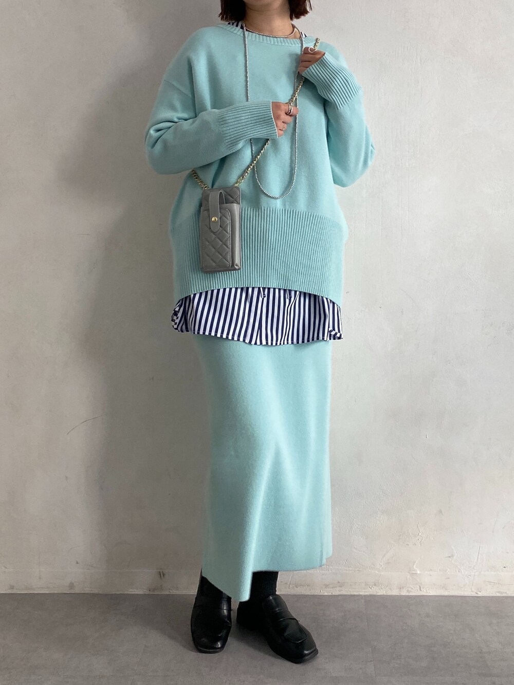 ブルー系のニット/セーター、ブルー系のシャツ/ブラウス、ブルー系のスカートを着用したレディースの冬コーディネートの5枚目の写真