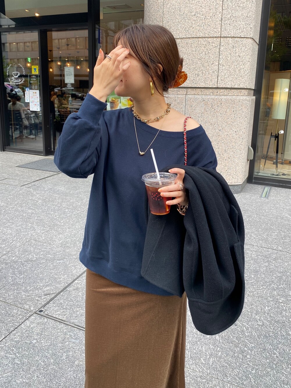 ブルー系のスウェット、ブラウン系のブーツ、レッド系のショルダーバッグを着用したレディースの秋コーディネートの5枚目の写真