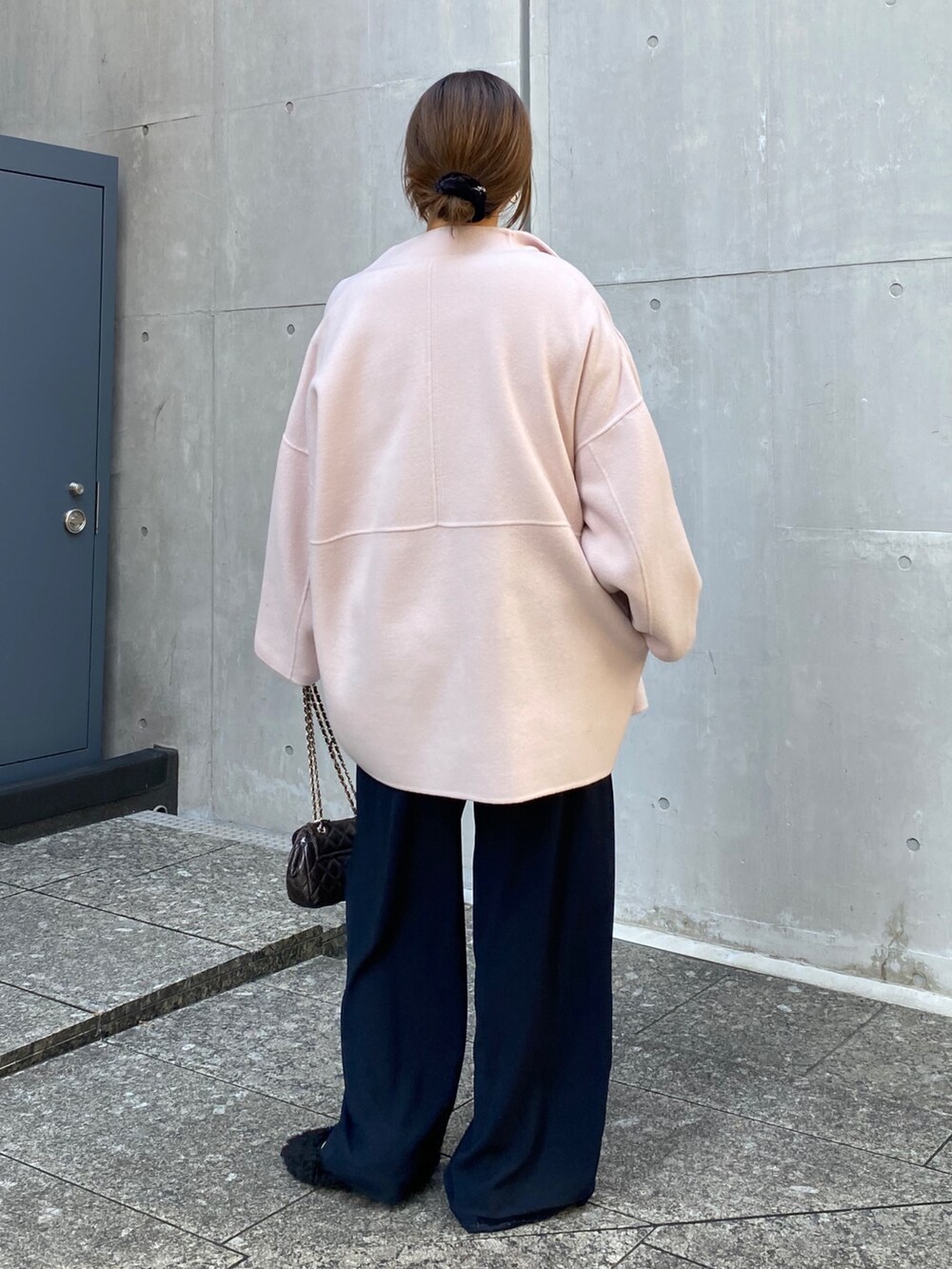 ピンク系のニット/セーター、ブルー系のスラックス、ブラウン系のショルダーバッグを着用したレディースの冬コーディネートの8枚目の写真