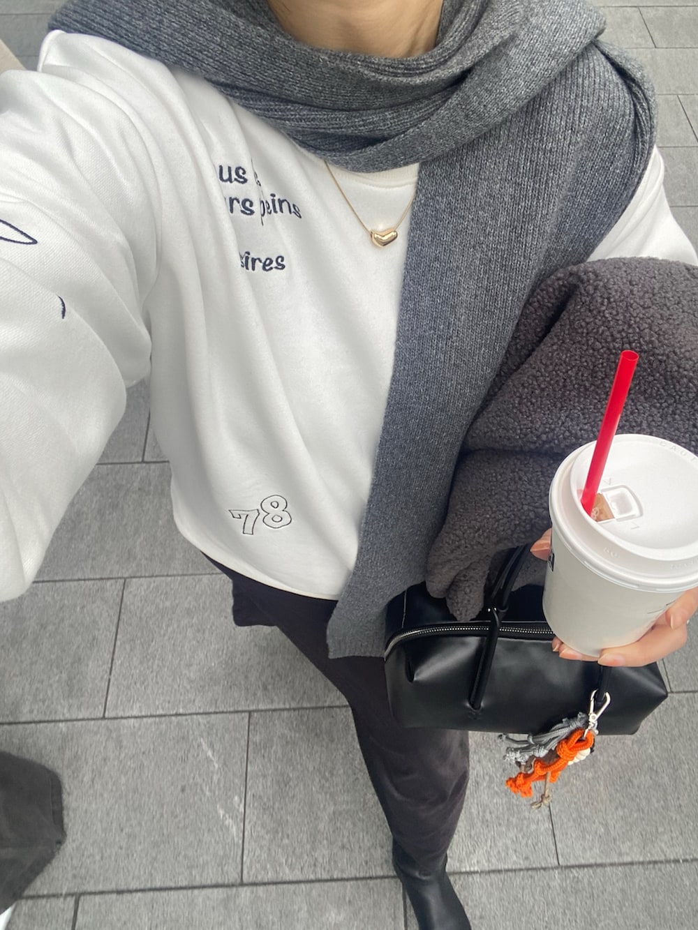 ホワイト系のTシャツ/カットソー、グレー系のスカート、グレー系のその他アウターを着用したレディースの冬コーディネートの8枚目の写真