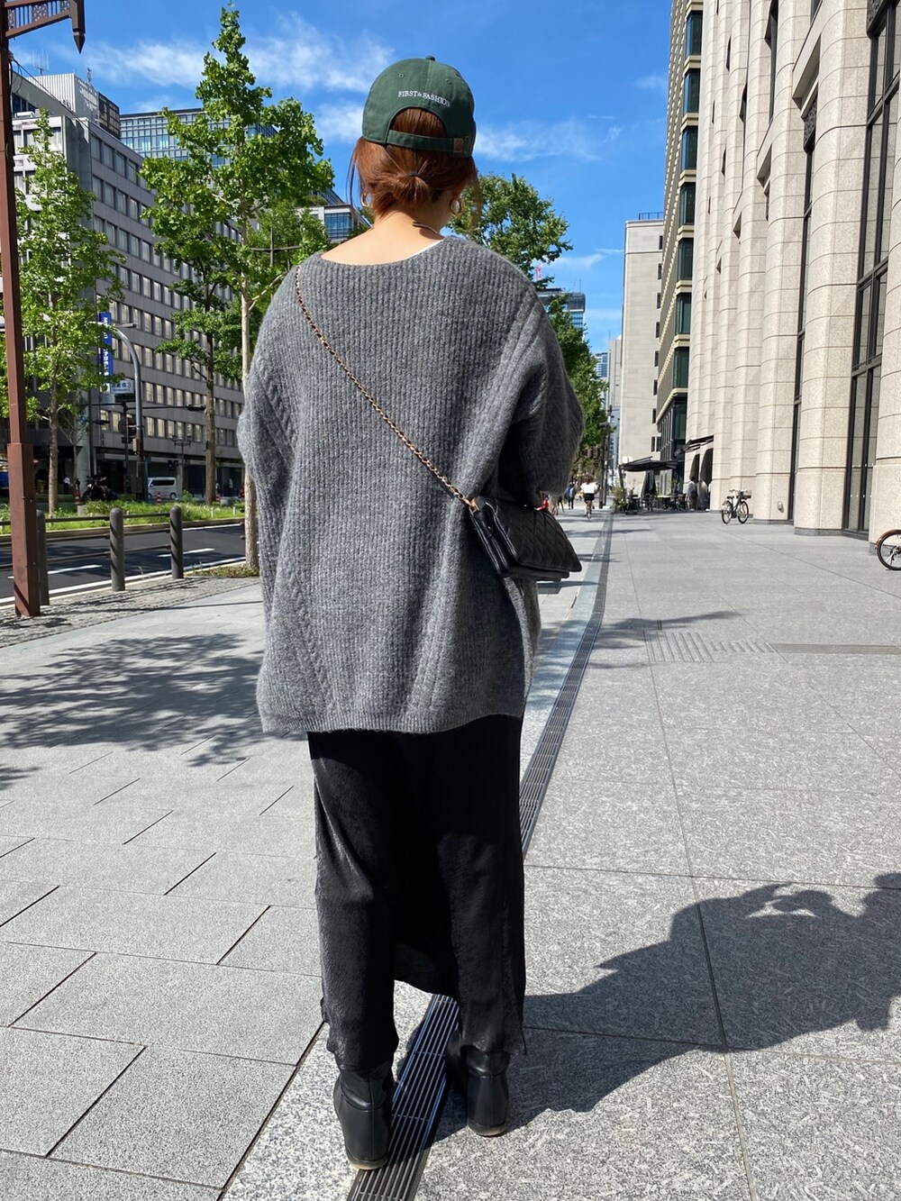 グレー系のニット/セーター、ブラック系のスカートを着用したレディースの秋コーディネートの4枚目の写真