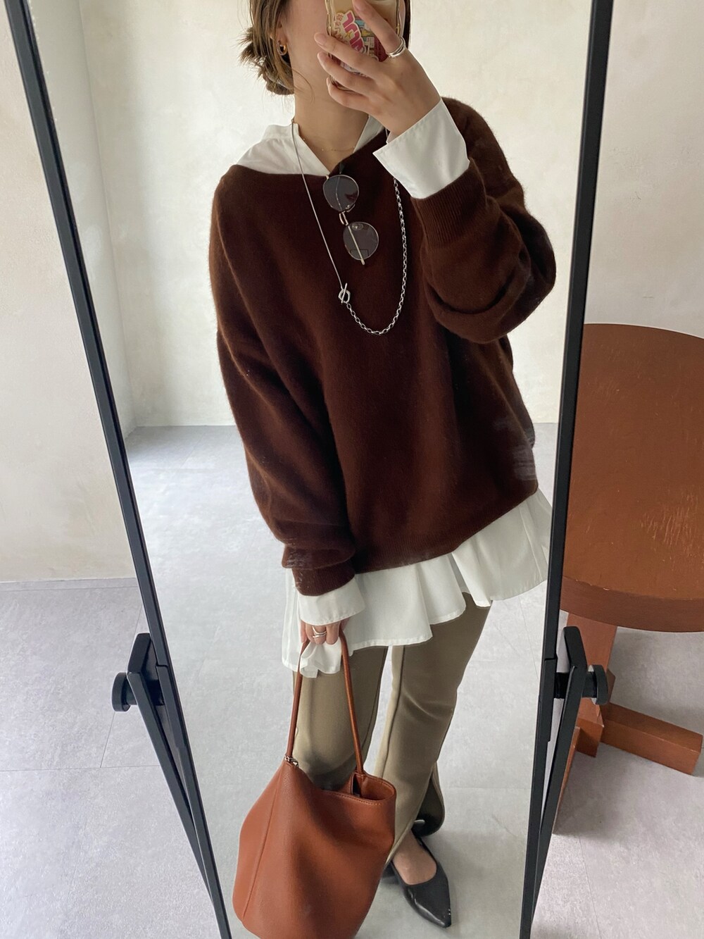 ブラウン系のニット/セーター、ホワイト系のシャツ/ブラウス、ベージュ系のその他パンツを着用したレディースの冬コーディネートの2枚目の写真