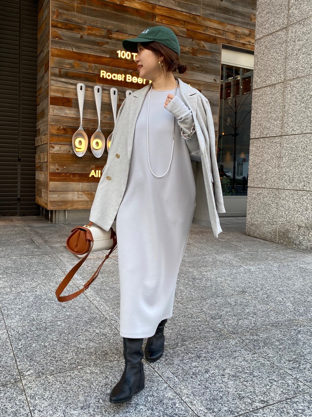 グレー系のテーラードジャケット、グレー系のワンピース、ブラウン系のショルダーバッグを着用したレディースの冬コーディネートの2枚目の写真