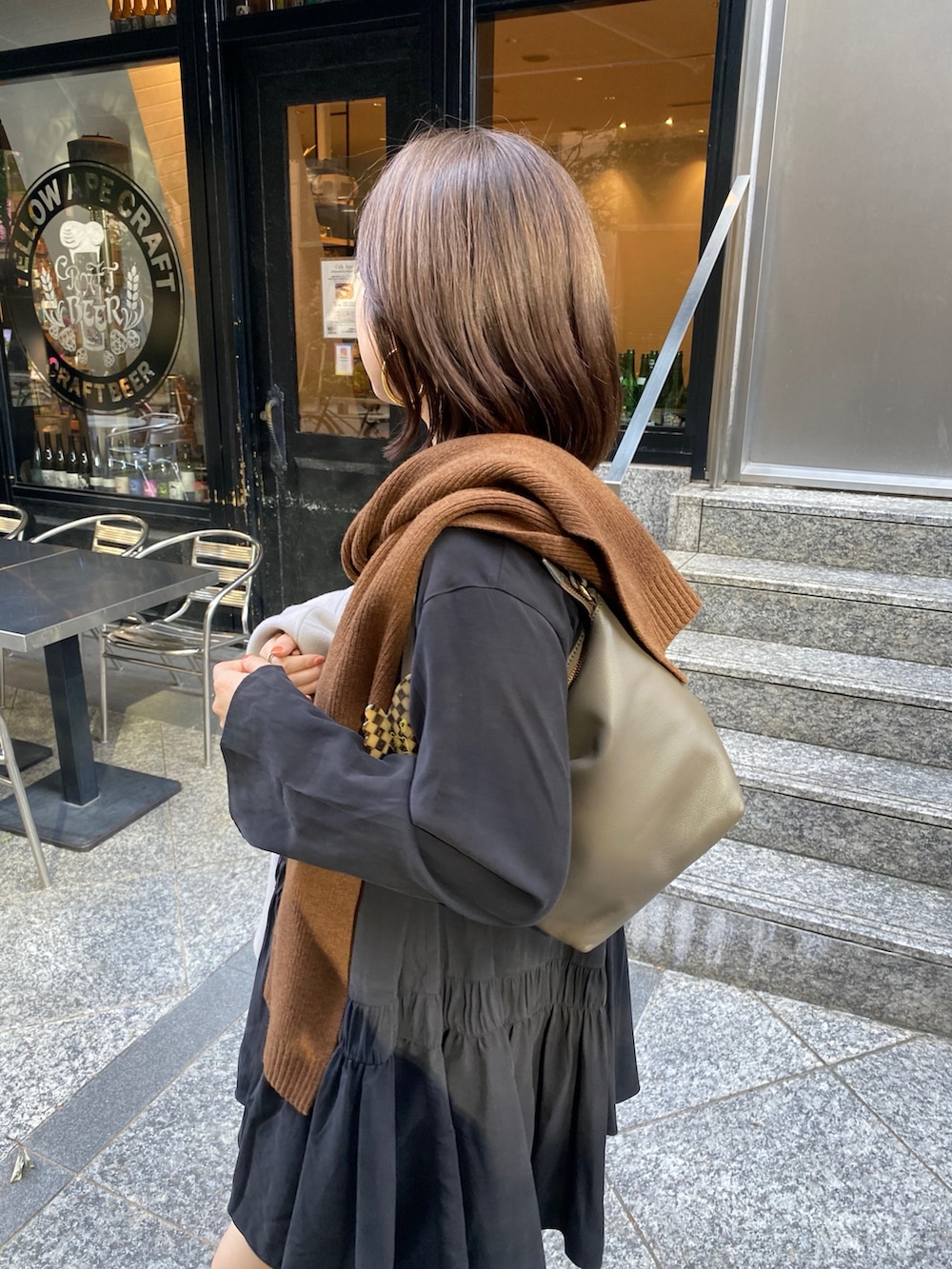 ブラック系のシャツ/ブラウス、ブラウン系のブーツ、ブラウン系のショルダーバッグを着用したレディースの秋コーディネートの4枚目の写真