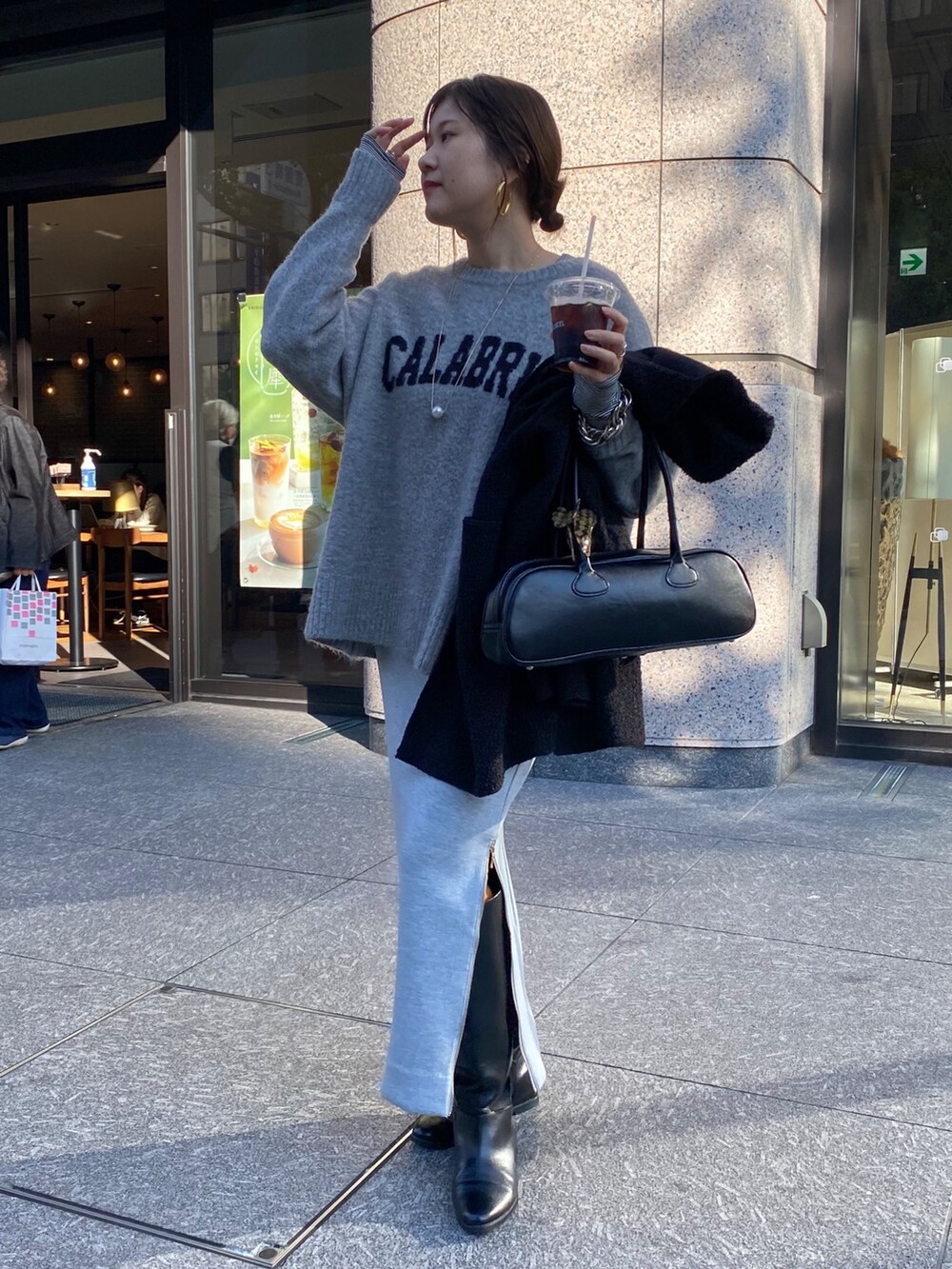 ホワイト系のTシャツ/カットソー、グレー系のニット/セーター、グレー系のスカートを着用したレディースの冬コーディネートの3枚目の写真