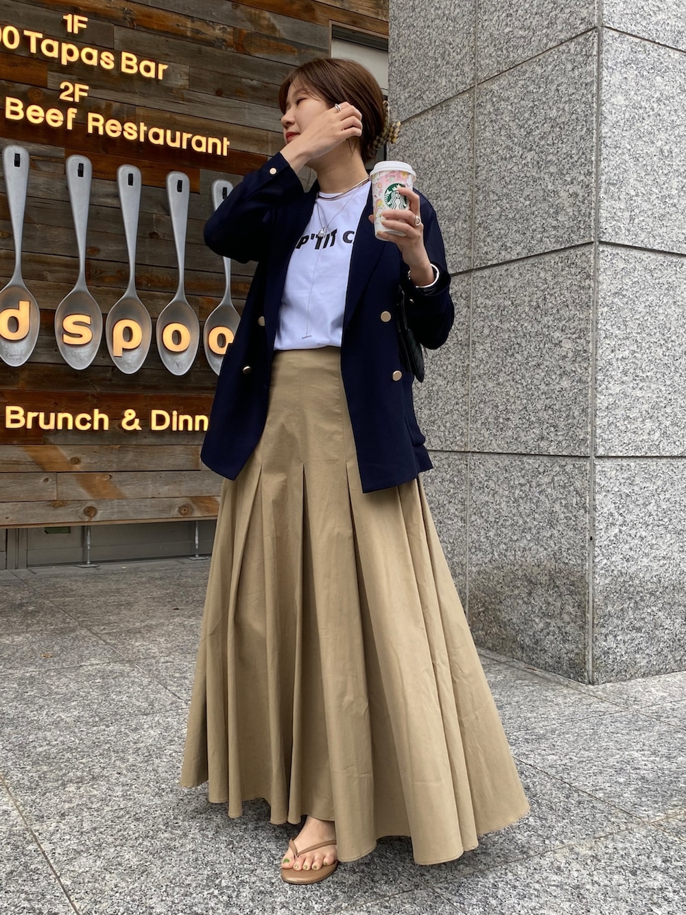 ホワイト系のTシャツ/カットソー、ブルー系のテーラードジャケット、ブラック系のスカートを着用したレディースの春コーディネートの5枚目の写真