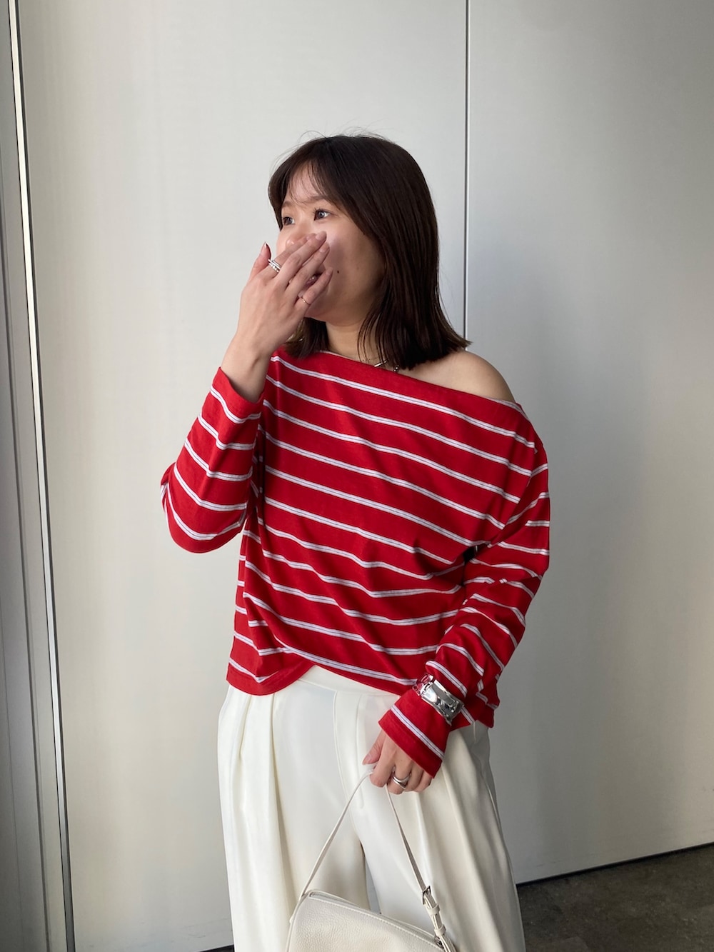 レッド系のTシャツ/カットソー、ホワイト系のスラックスを着用したレディースの春コーディネートの4枚目の写真