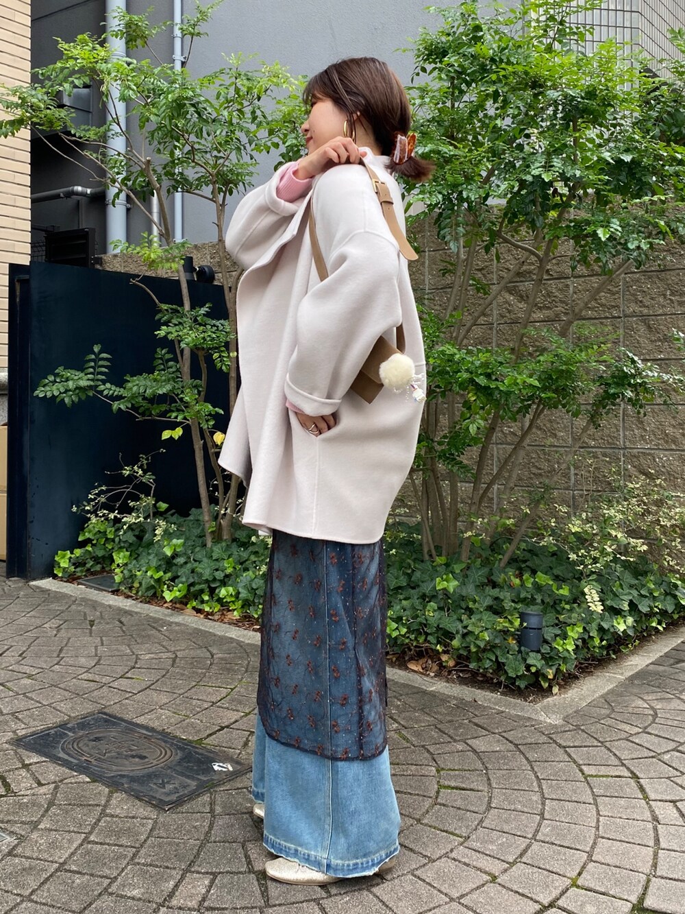 ホワイト系のその他アウター、ピンク系のニット/セーター、ブラック系のスカートを着用したレディースの冬コーディネートの2枚目の写真