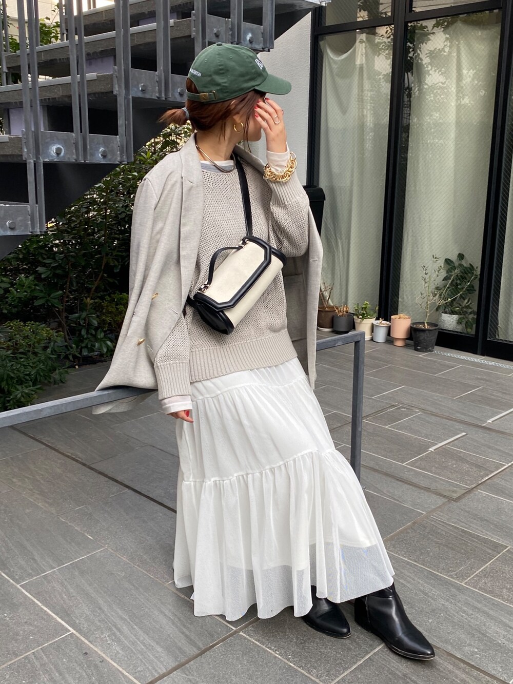 ホワイト系のニット/セーター、グレー系のテーラードジャケット、グリーン系のスカートを着用したレディースの春コーディネートの6枚目の写真