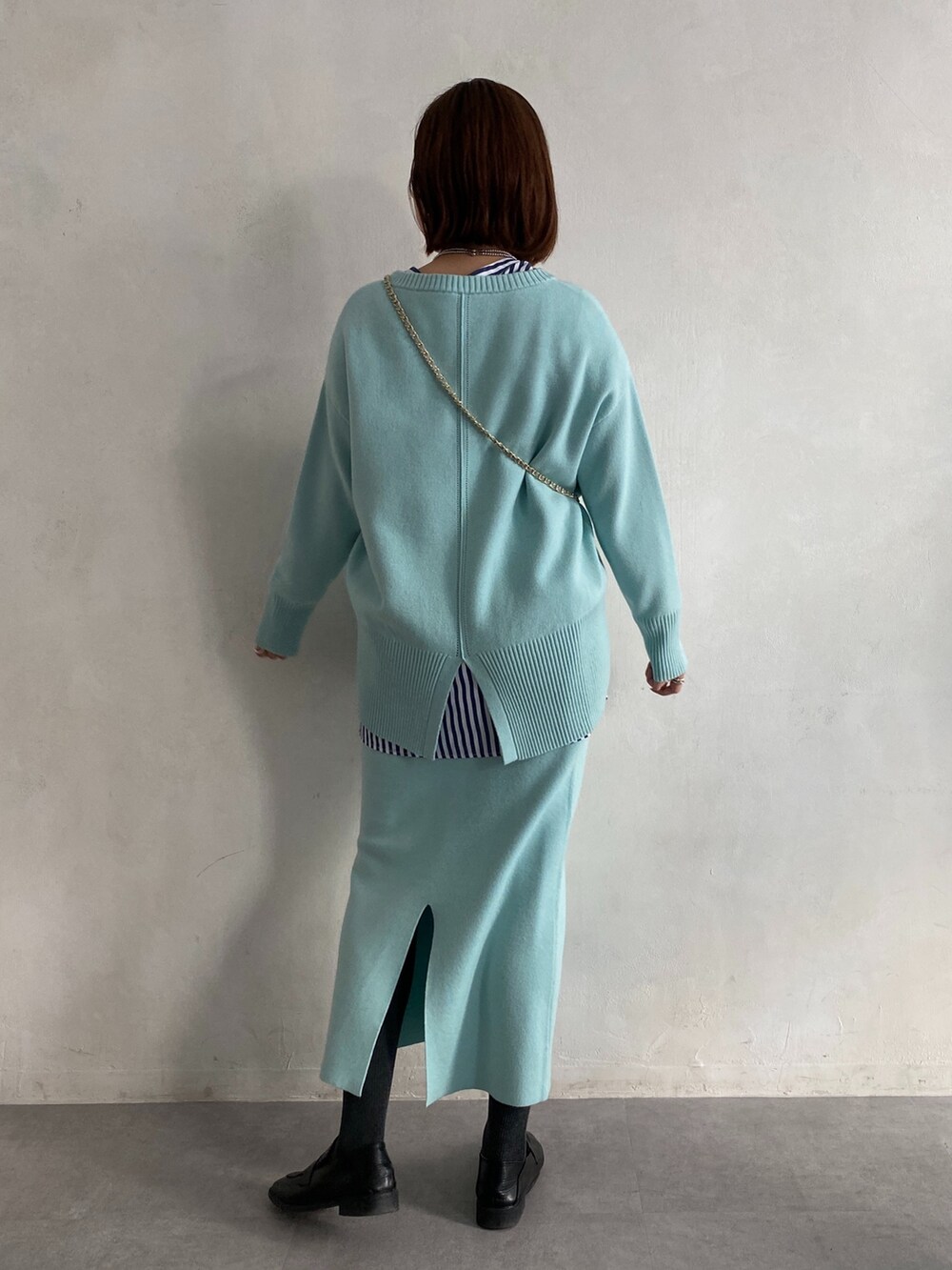 ブルー系のニット/セーター、ブルー系のシャツ/ブラウス、ブルー系のスカートを着用したレディースの冬コーディネートの3枚目の写真