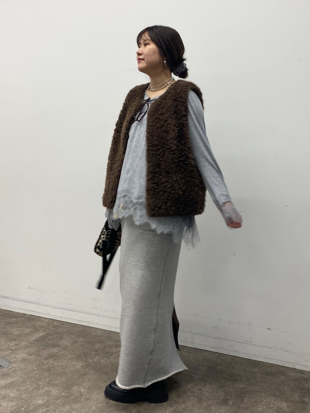 グレー系のTシャツ/カットソー、グレー系のスカートを着用したレディースの冬コーディネートの3枚目の写真