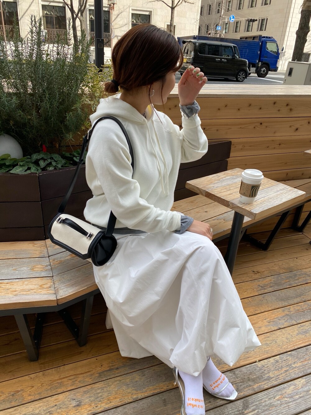 ホワイト系のスカート、ブラウン系のショルダーバッグ、グレー系のTシャツ/カットソーを着用したレディースの春コーディネートの5枚目の写真