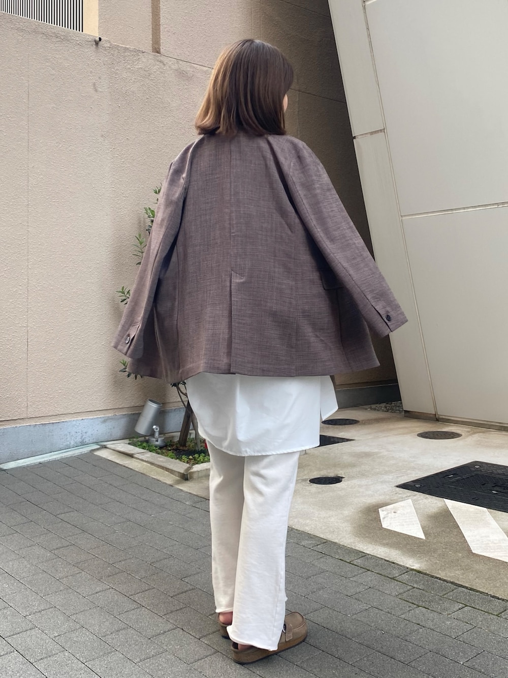 ブラウン系のテーラードジャケット、レッド系のTシャツ/カットソー、ホワイト系のシャツ/ブラウスを着用したレディースの春コーディネートの2枚目の写真