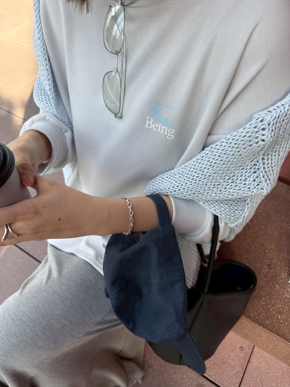 グレー系のTシャツ/カットソー、ブルー系のニット/セーター、グレー系のスカートを着用したレディースの冬コーディネートの4枚目の写真