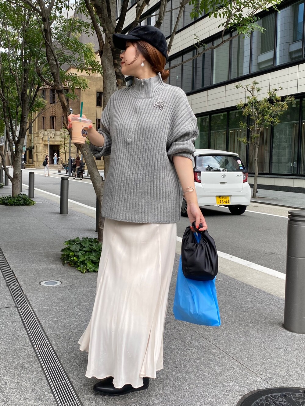 ベージュ系のワンピース、ホワイト系のスカート、ブラック系のブーツを着用したレディースの冬コーディネートの7枚目の写真