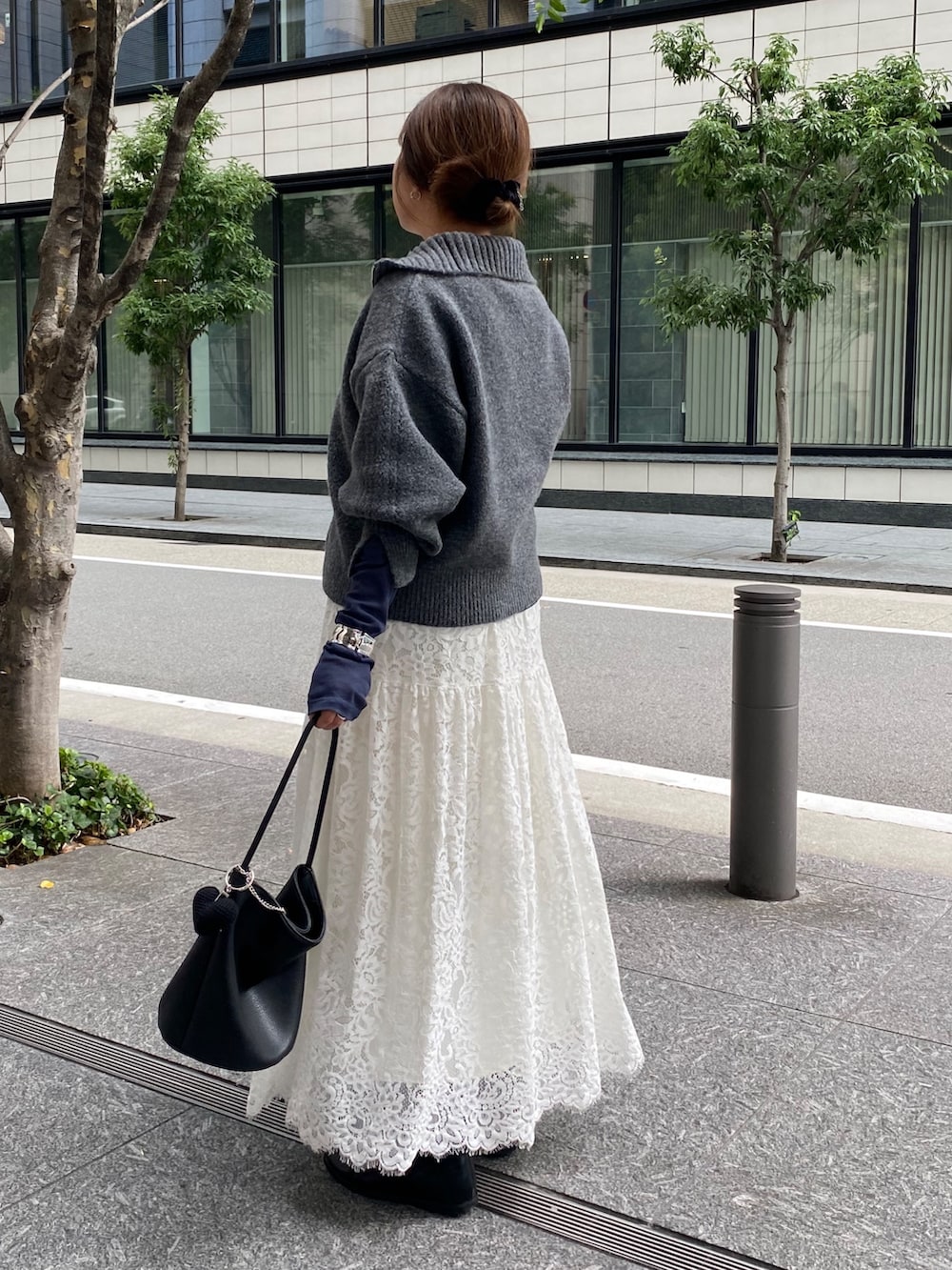 グレー系のカーディガン/ボレロ、ブルー系のTシャツ/カットソー、ホワイト系のスカートを着用したレディースの秋コーディネートの4枚目の写真