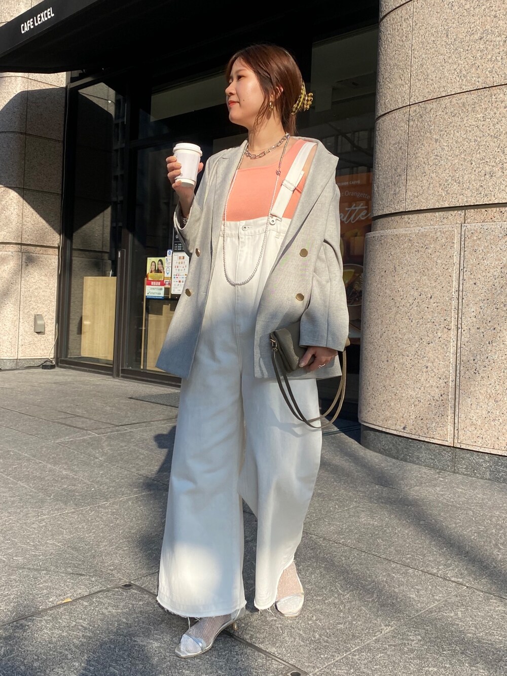 ピンク系のタンクトップ、ホワイト系のサロペット/オーバーオール、グレー系のテーラードジャケットを着用したレディースの春コーディネートの2枚目の写真