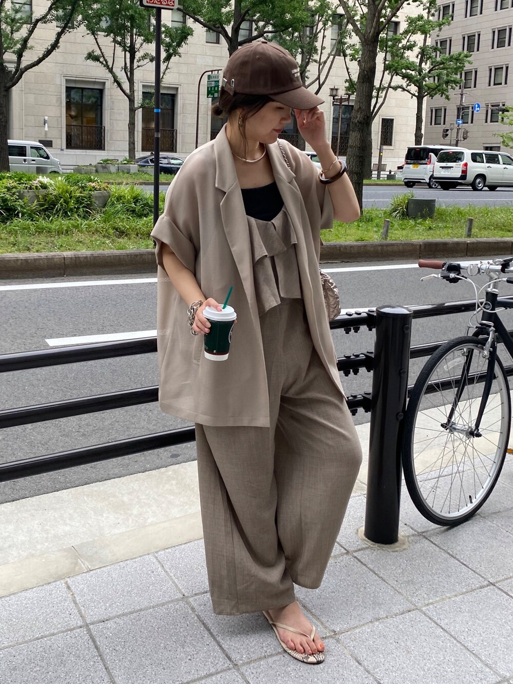 ベージュ系のテーラードジャケット、ベージュ系のつなぎ/オールインワン、ブラウン系のキャップを着用したレディースの夏コーディネートの6枚目の写真