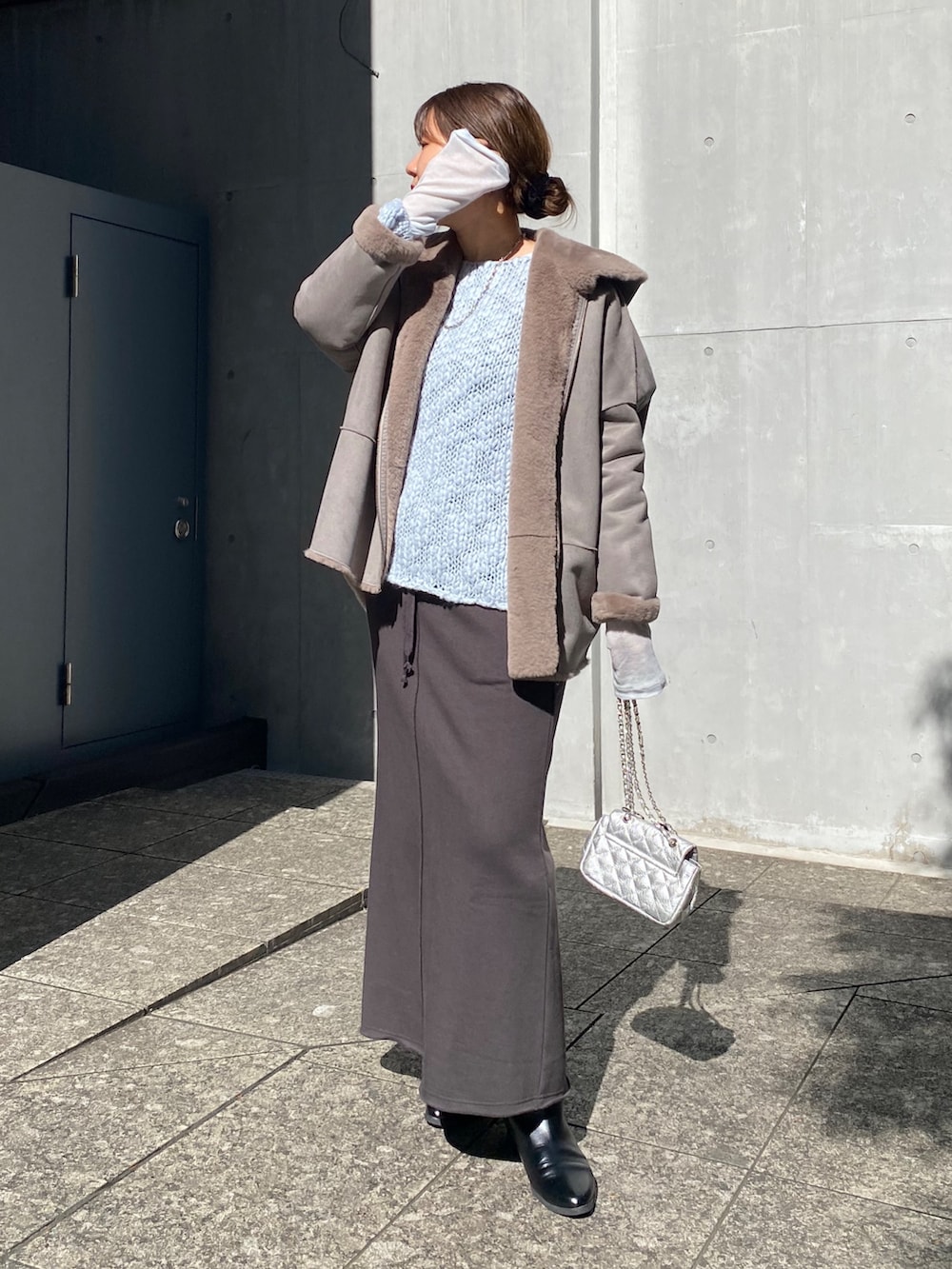 ブルー系のニット/セーター、ブルー系のTシャツ/カットソー、グレー系のムートンコートを着用したレディースの冬コーディネートの10枚目の写真