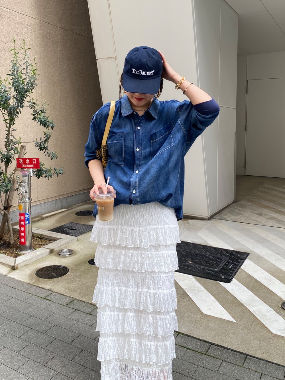 ブルー系のシャツ/ブラウス、ホワイト系のスカート、ゴールド系のネックレスを着用したレディースの春コーディネートの8枚目の写真