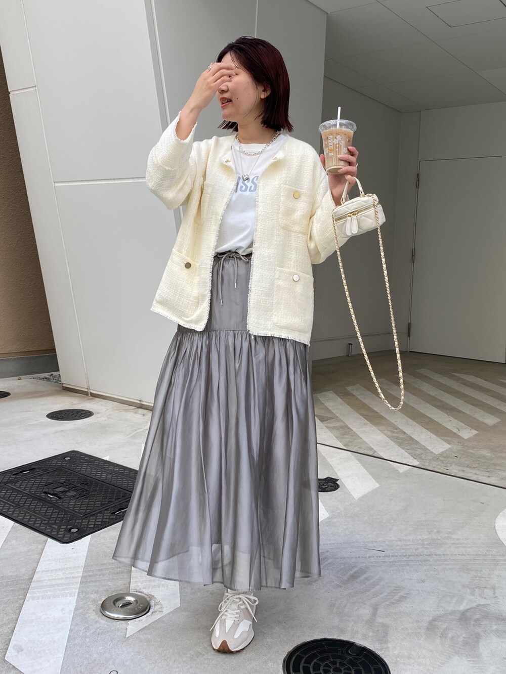 ホワイト系のノーカラージャケット、ホワイト系のスニーカー、ブラック系のショルダーバッグを着用したレディースの春コーディネートの7枚目の写真