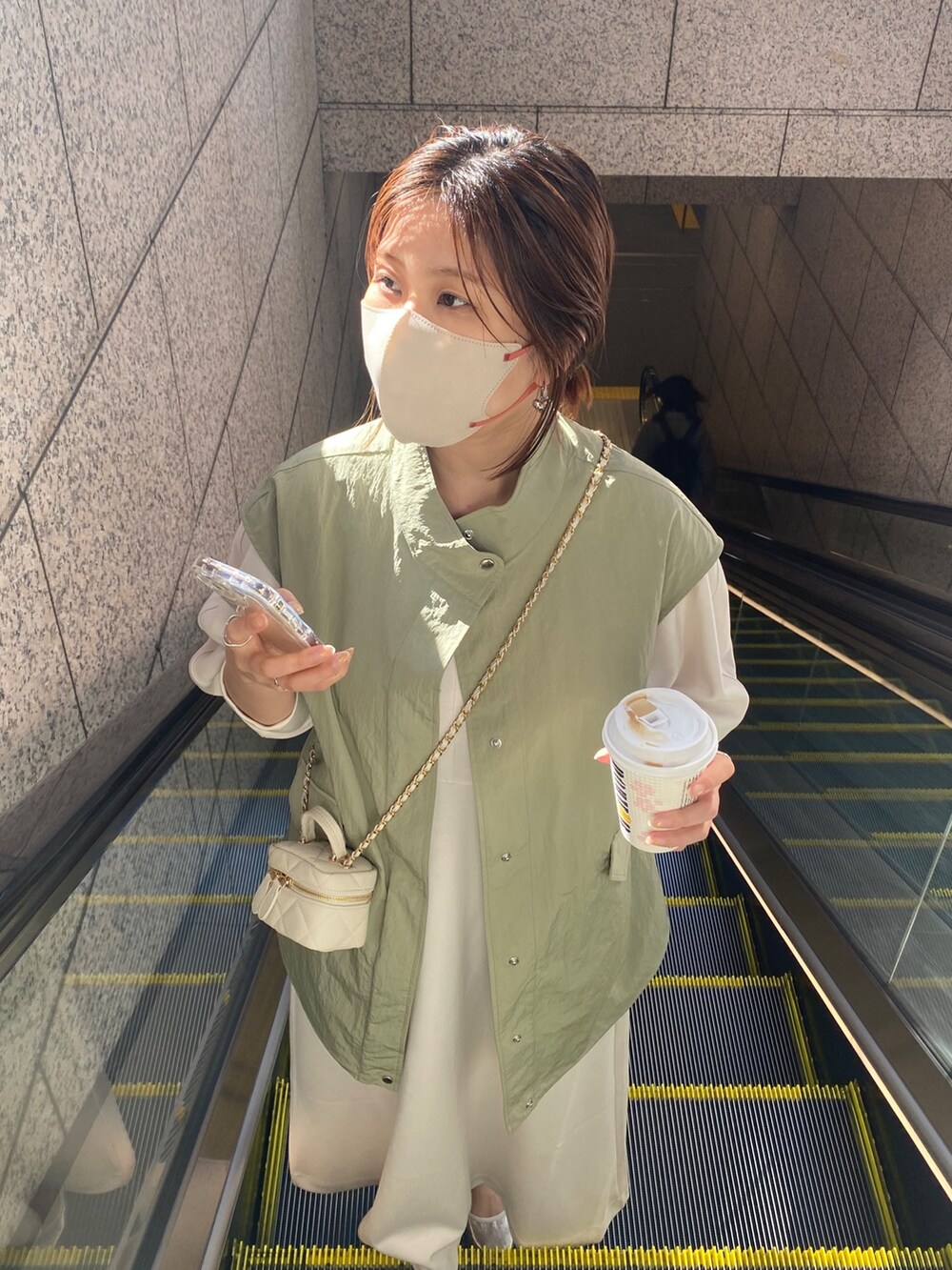 ホワイト系のワンピース、ブラック系のショルダーバッグを着用したレディースの春コーディネートの10枚目の写真