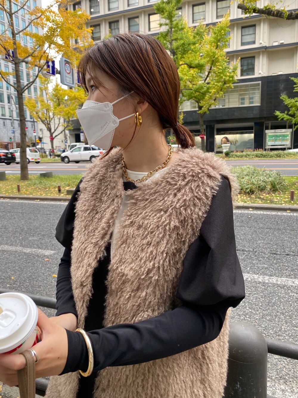 ベージュ系のベスト、ブラック系のワンピースを着用したレディースの秋コーディネートの5枚目の写真