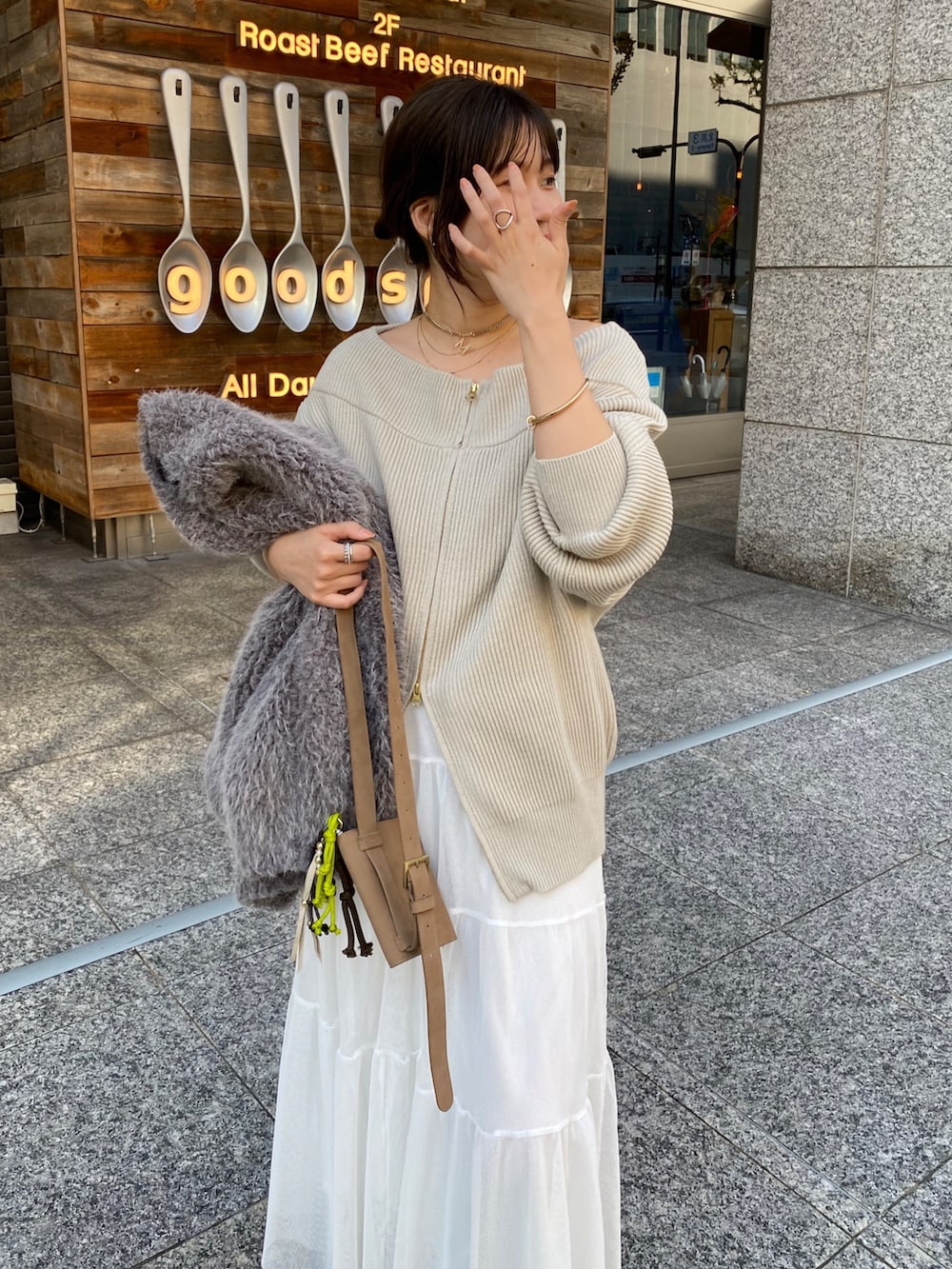 ベージュ系のニット/セーター、ホワイト系のスカート、グレー系のその他アウターを着用したレディースの冬コーディネートの9枚目の写真
