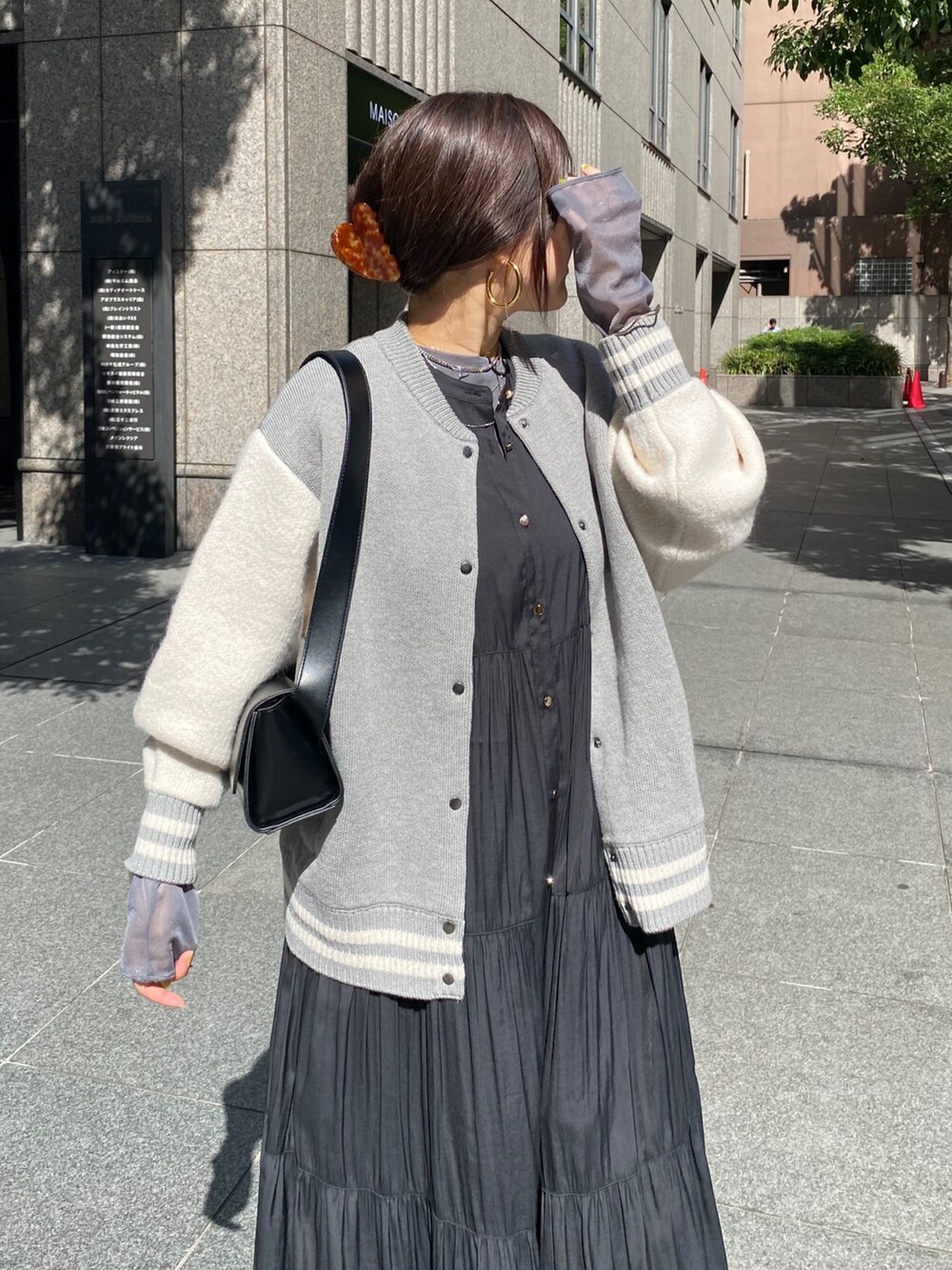 グレー系のその他アウター、ブラック系のワンピース、ブラック系のブーツを着用したレディースの秋コーディネートの3枚目の写真