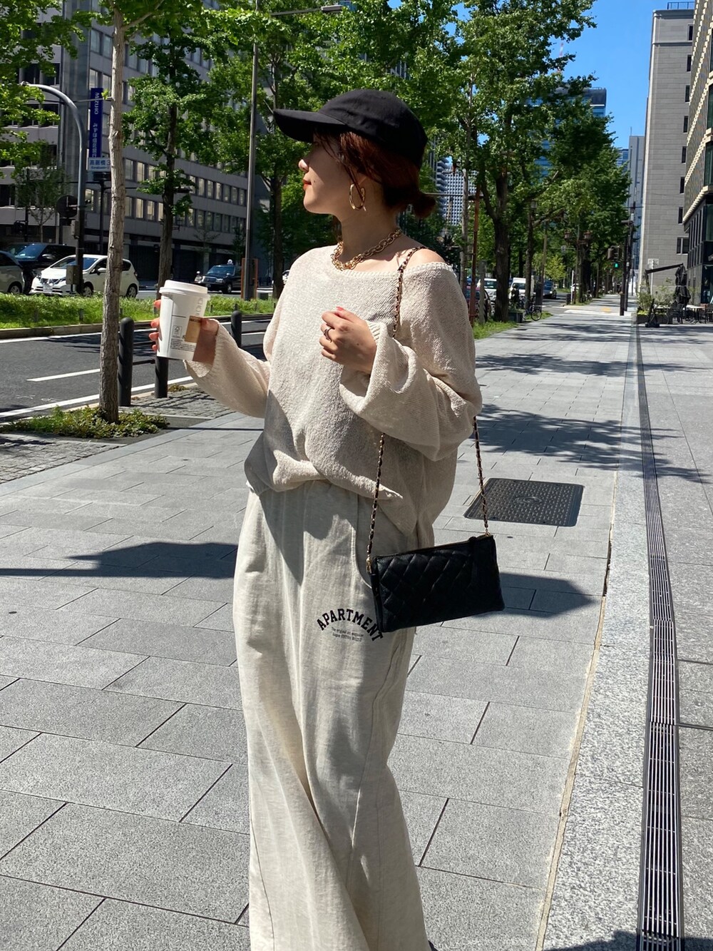 ベージュ系のニット/セーター、ベージュ系のスカート、ブラック系のショルダーバッグを着用したレディースの夏コーディネートの8枚目の写真