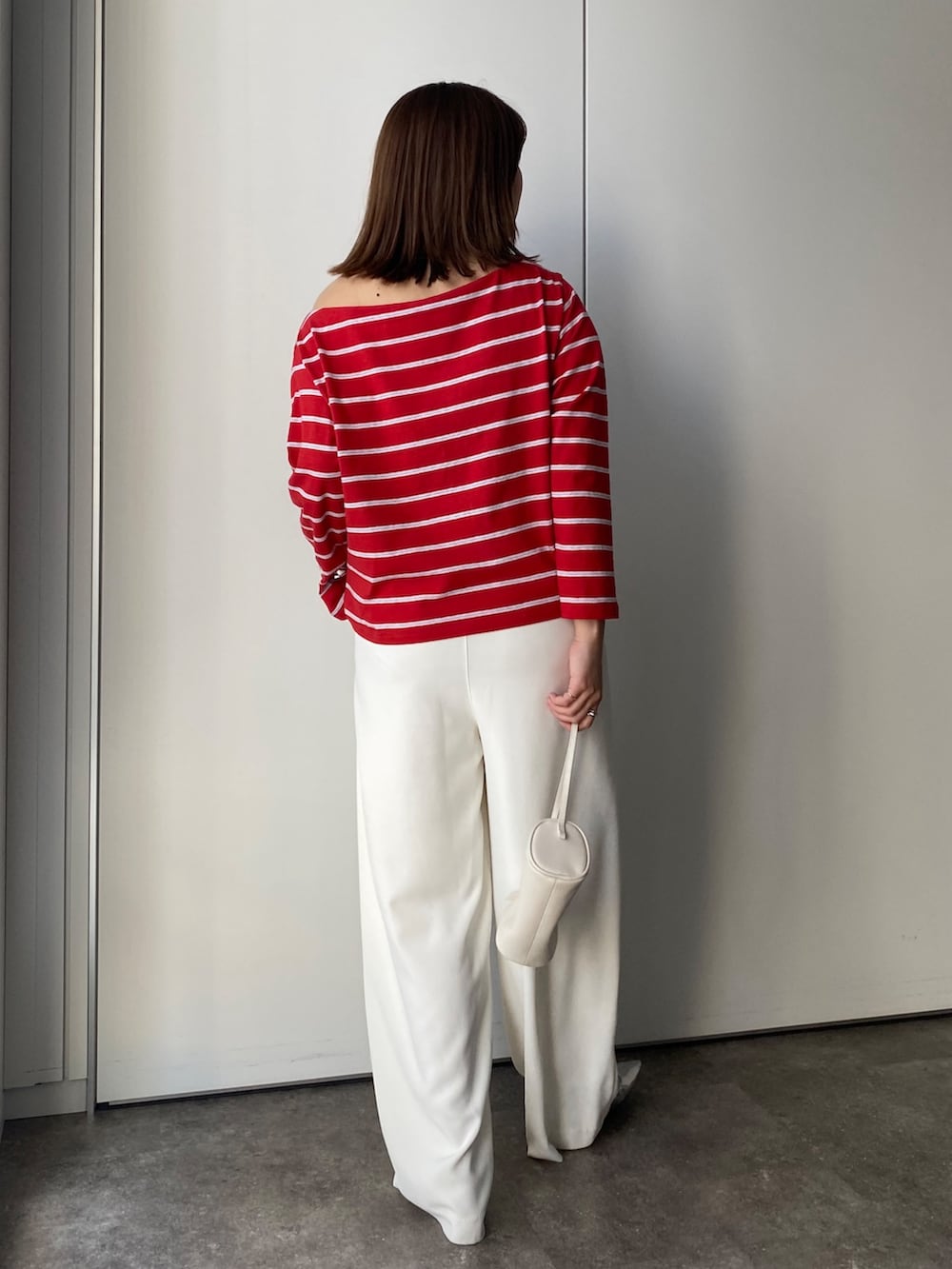 レッド系のTシャツ/カットソー、ホワイト系のスラックスを着用したレディースの春コーディネートの2枚目の写真