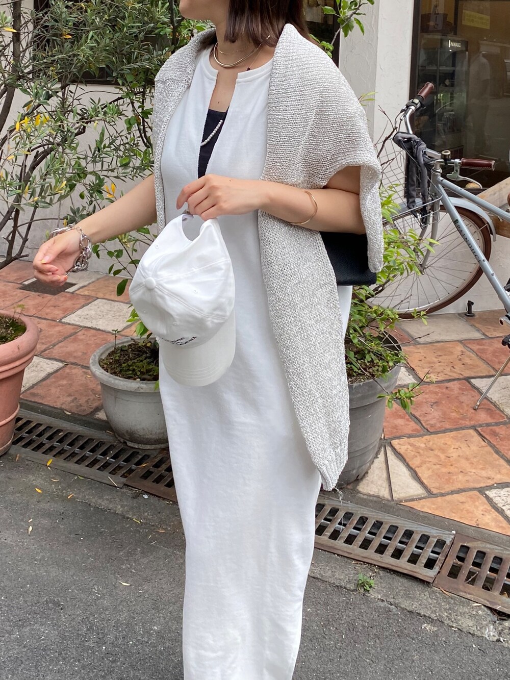 ホワイト系のワンピース、ホワイト系のキャップ、ホワイト系のネックレスを着用したレディースの夏コーディネートの8枚目の写真