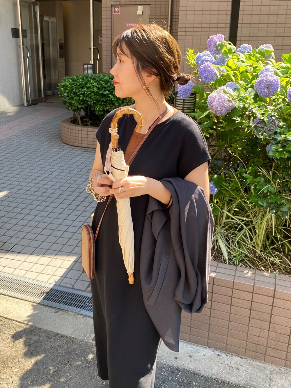 ブラック系のワンピース、ブラウン系のTシャツ/カットソーを着用したレディースの夏コーディネートの2枚目の写真